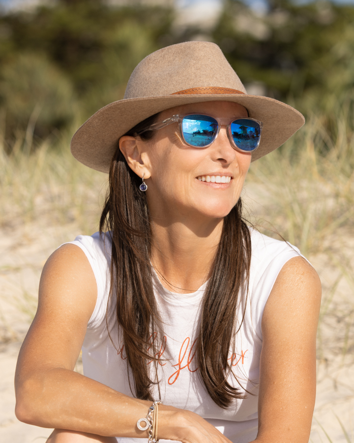 Woman traveller sitting on the beach and smiling