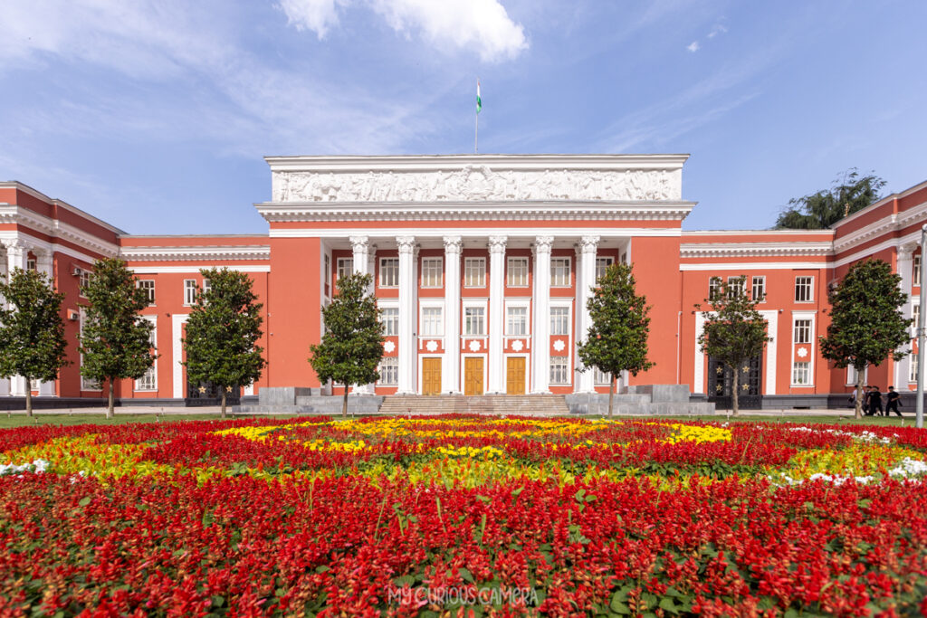 This building is the former ⁠Parliament House of Tajikistan (the former Supreme Soviet building), located directly on Dousti Square (Friendship Square) in central Dushanbe. Built in the classical Soviet neoclassical style with a distinct terracotta-orange facade and white columns, it served as the home of the country's legislature for decades.