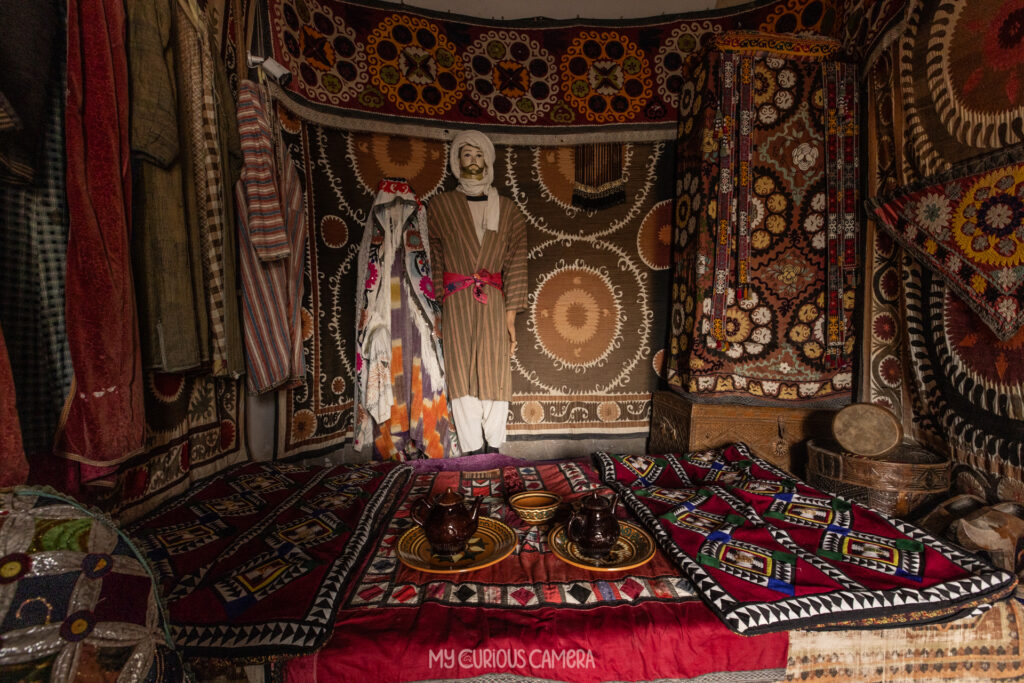 Inside the museum, this beautifully decorated formal room is bursting with colour and texture. The embroidered textiles feature circular solar medallions, symbols of fertility, light and protection. Layered kurpacha quilts surround a low table where families would gather to share tea.